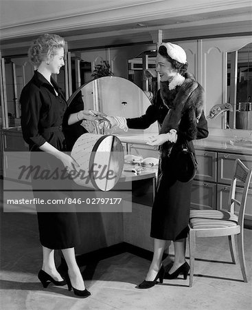 1950s WOMAN IN HAT STOLE & GLOVES TAKING HATBOX FROM SALESWOMAN