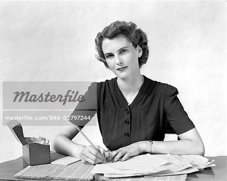 1940s WOMAN AT DESK GOING THROUGH PAPERWORK PAYING BILLS