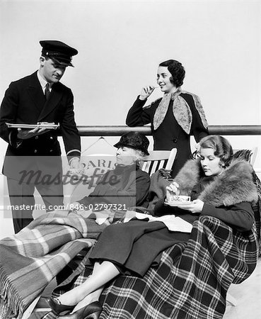 1930s THREE WOMEN BEING SERVED TEA BY A STEWARD ON BOARD AN OCEAN LINER CROSSING THE ATLANTIC OCEAN