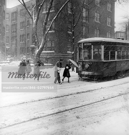 1940s CITY WINTER SCENE PEDESTRIANS CROSSING STREET SNOW TROLLEY CAR TRANSPORTATION