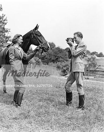 1940s SMILING EQUESTRIAN COUPLE THE WOMAN IS HOLDING THE HORSES BRIDLE THE MAN IS TAKING MOVIES OF THEM
