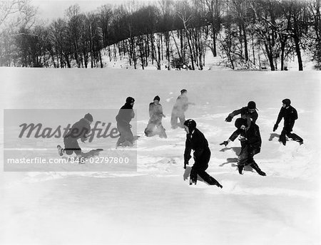 1930s GROUP 8 BOYS HAVING A MASSIVE SNOWBALL FIGHT NEAR WOODS