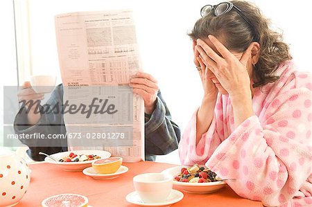 Tired woman with her husband having breakfast