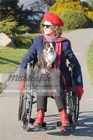 Woman in wheelchair with dog on her lap