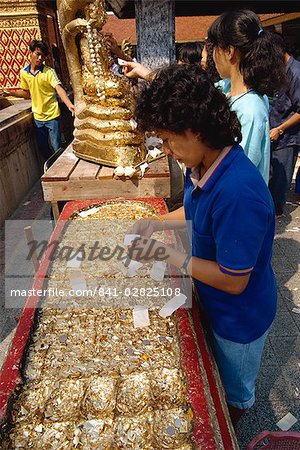 Woman with gold leaf, Wat Phra That Doi Suthep, Chiang Mai, Thailand, Southeast Asia, Asia