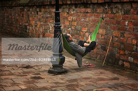 Man Sleeping in Hammock on Street, Hanoi, Vietnam