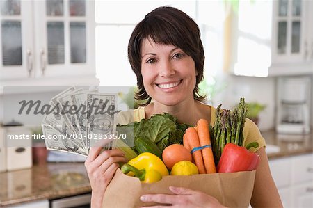 Femme tenant un sac d'épicerie et de trésorerie