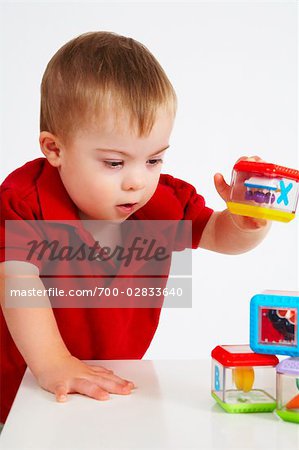 Garçon avec Down syndrome jouant avec des jouets sur la Table