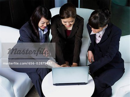 trois femmes travaillant à l'ordinateur portable ensemble