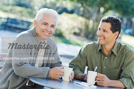 Father and Son Having Coffee at Outdoor Cafe