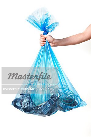 Person Holding Blue Recycling Bag Full of Electronics