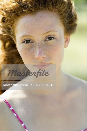 Young red haired woman looking at camera, portrait