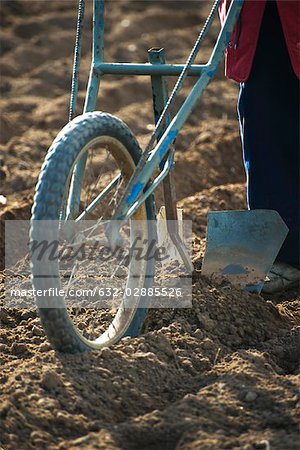 Farmer behind plow turning soil in field