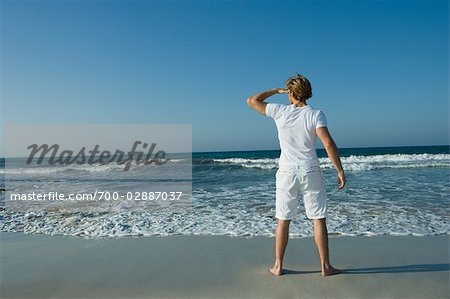 Homme sur la plage regardant au loin, Ibiza, Espagne