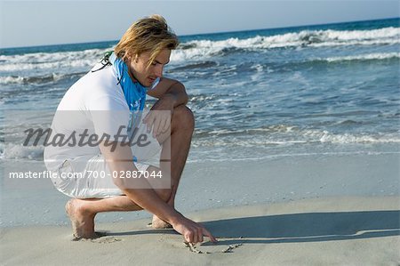 Homme sur la plage de dessin dans le sable, Ibiza, Espagne