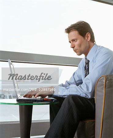 Businessman using Laptop at Airport