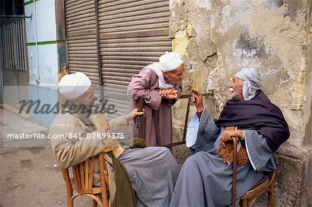 Three old men outside talking in a street in Cairo, Egypt, North Africa, Africa