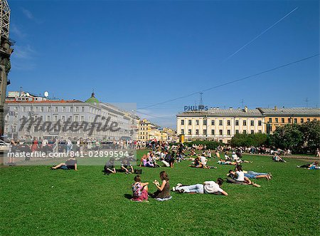 Gens se détendre sur l'herbe en été dans la perspective Nevski, dans la ville de Saint-Pétersbourg, Russie, Europe