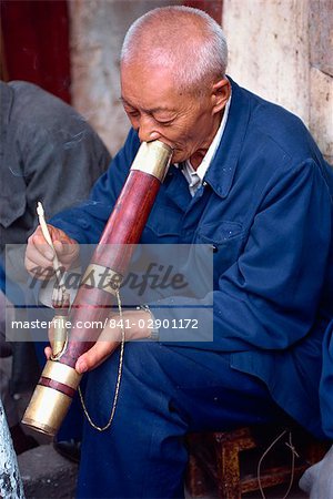 Portrait d'un homme fumant une longue pipe dans une maison de thé à Kunming, Chine, Asie