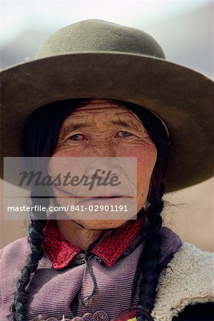 Portrait of a Tibetan woman with plaits and hat on the Qinghai Plateau, China, Asia