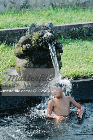 Garçon sous une eau du bec, WaterTemple, Bali, Indonésie