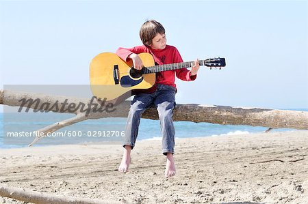 Kleiner Junge, die Gitarre zu spielen, am Strand