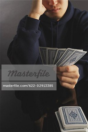 Homme tenant un jeu de cartes dans ses mains