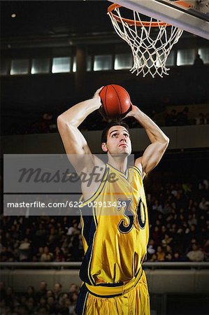 Young man holding basketball over his head