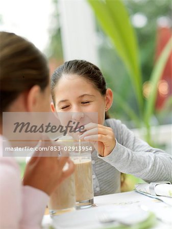 Two girls drinking with straw