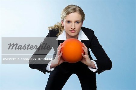 Femme d'affaires tient ballon, vue de face