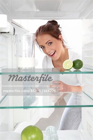 Femme buvant le lait du frigo