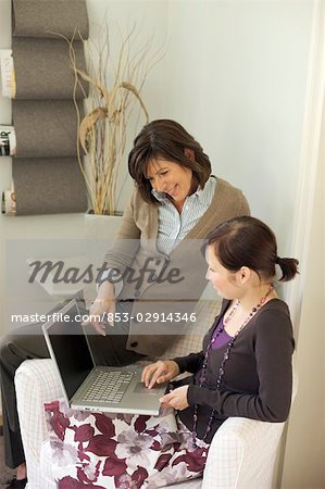 Mère et fille à la recherche sur un ordinateur portable