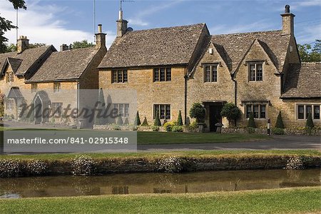 Stone cottages along the banks of the River Eye, Lower Slaughter, The Cotswolds, Gloucestershire, England, United Kingdom, Europe