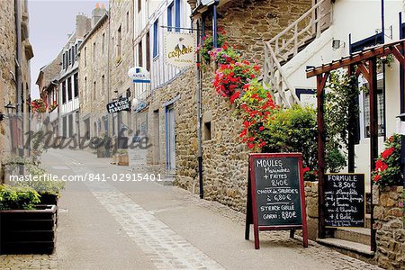 Schmale Straße mit halben Fachwerkhäuser und Fischrestaurants, Treguier, Côte de Granit Rose, Cotes d ' Armor, Bretagne, Frankreich, Europa