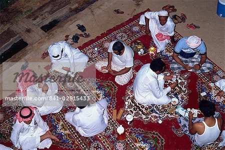 Overhead view of a group of men gathering for tea, cards and dominoes, Saudi Arabia, Middle East