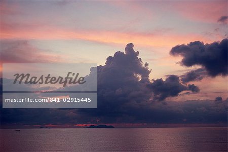 Towering dark grey clouds in a pink and blue sky over the sea in Malaysia, Southeast Asia, Asia
