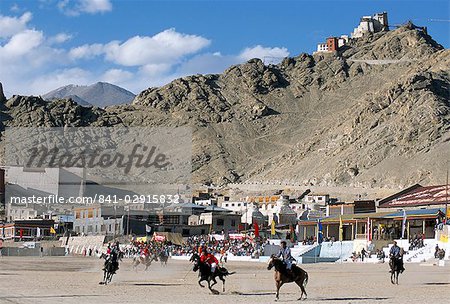 Game of polo on Leh polo field, Tsemo Gompa on ridge behind, Leh, Ladakh, India, Asia