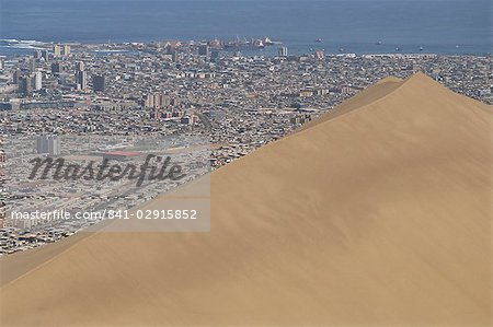 Giant sand dune above large city, Iquique, Atacama coast, Chile, South America