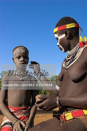 Woman painting her daughter's face, Mago National Park, Lower Omo Valley, Ethiopia, Africa