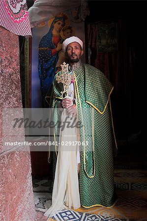 Priest with cross, Bet Meskel, an excavated chapel in the northern wall of the courtyard of Bet Maryam, Lalibela, Ethiopia, Africa Priest with cross, Bet Meskel, an excavated chapel in the northern wall of the courtyard of Bet Maryam, Lalibela, Ethiopia, Africa