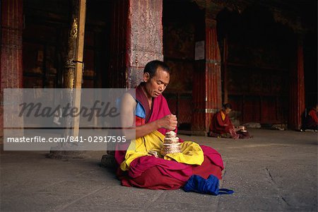 Monks sitting inside Jokhang temple, The Barkor, Lhasa, Tibet, China, Asia