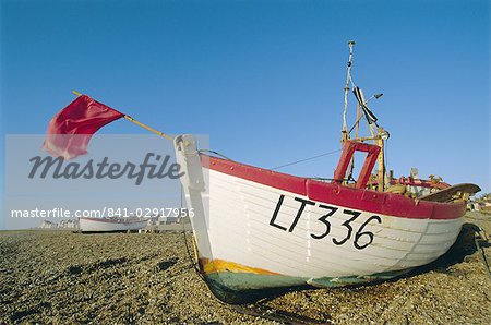 Bateau de pêche avec le drapeau rouge sur la plage, à Aldeburgh, Suffolk, Angleterre, Royaume-Uni, Europe