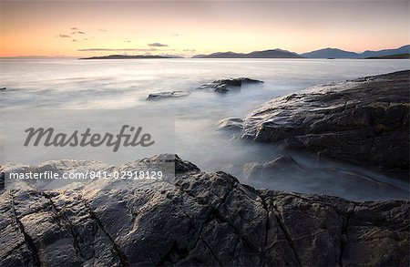 Abenddämmerung Blick über das offene Wasser in Richtung Taransay und North Harris von der felsigen Küste von Borve, Isle of Harris, Äußere Hebriden, Schottland, Vereinigtes Königreich, Europa