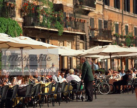 Tourists at a pavement cafe on the Piazza Navona in the city of Rome, Lazio, Italy, Europe