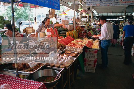 Un commerçant pointant à fruits sur l'un des aliments se bloque dans le marché de week-end à Bangkok, Thaïlande, Asie du sud-est, Asie