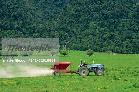 Spraying fertiliser on field for sheep grazing on coastal area near Hokitka, South Island, New Zealand, Pacific