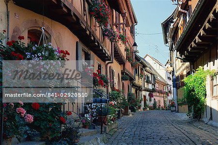 Flower-filled village street, Eguisheim, Haut-Rhin, Alsace, France, Europe