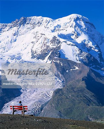 Hiker on bench, The Breithorn and Breithorn Glacier, Rotenboden, Zermatt, Valais, Switzerland, Europe