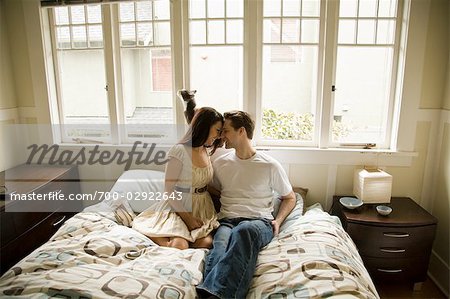 Couple at Home Sitting on Bed