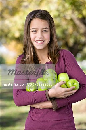 Jeune fille tenant un bouquet de pommes
